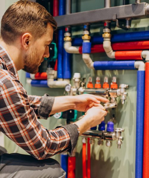 Young engineer adjusting autonomous heating Young engineer adjusting autonomous heating